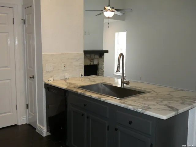 a bathroom with a granite countertop sink and a mirror
