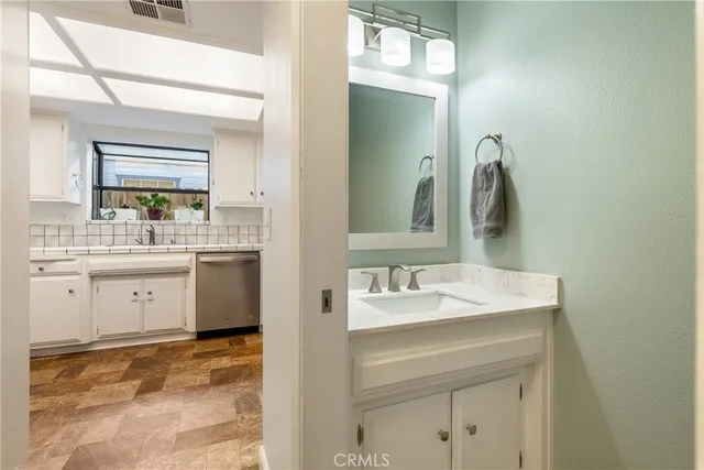 a bathroom with a sink vanity and mirror