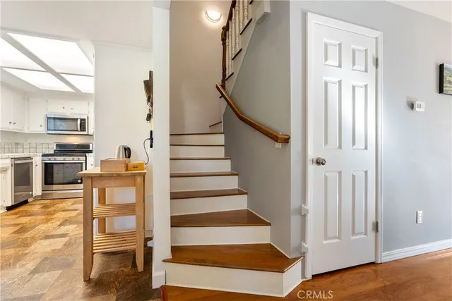 a view of a livingroom with wooden floor and stairs