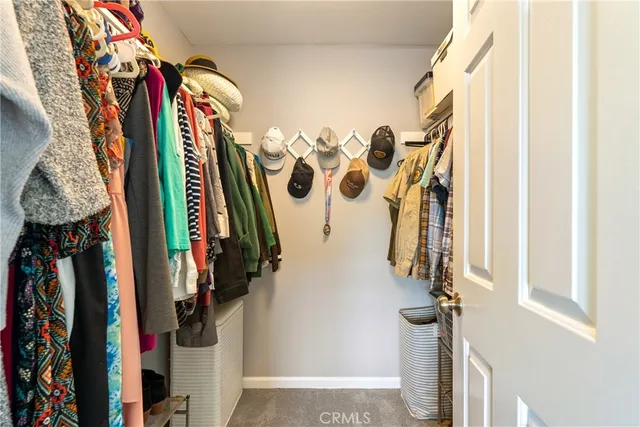 a view of walk in closet with clothes
