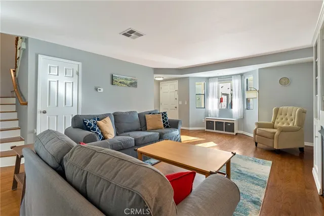 a living room with furniture and wooden floor