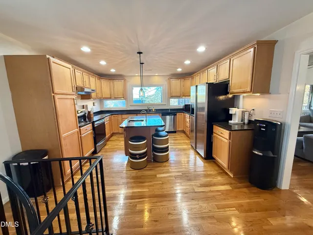 a kitchen with stainless steel appliances wooden cabinets a sink a window and a counter space