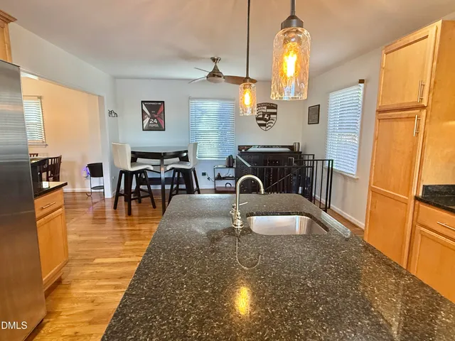 a kitchen with stainless steel appliances granite countertop a sink a refrigerator and a stove