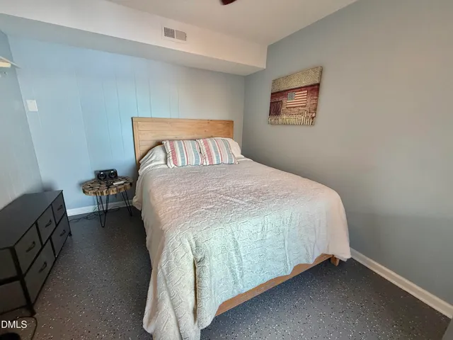 a bedroom with a bed and a wooden floor