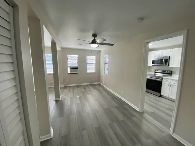 wooden floor in an empty room with a kitchen