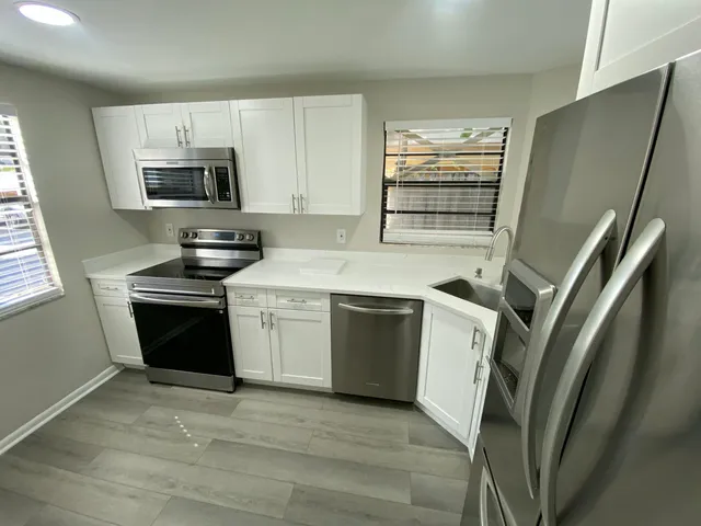 a kitchen with a sink stove and refrigerator