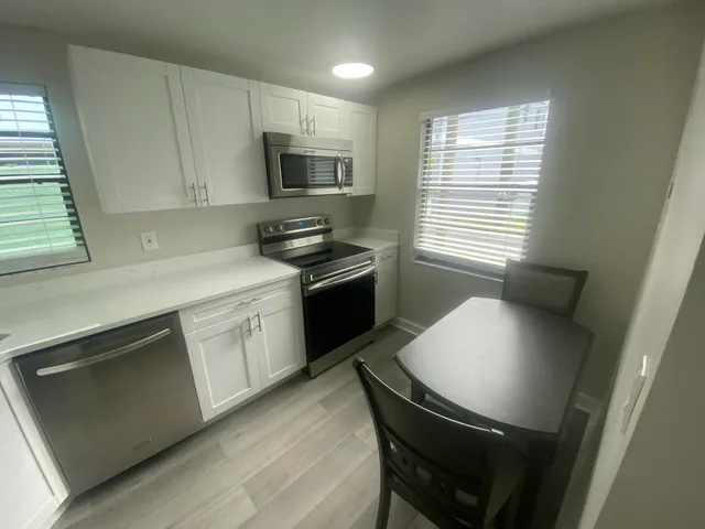 a kitchen with stainless steel appliances a stove a sink a microwave cabinets and a refrigerator