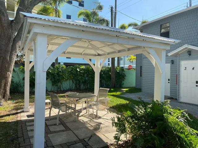 a view of a patio with table and chairs potted plants