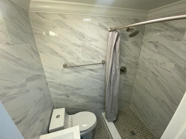 a bathroom with a toilet and a shower