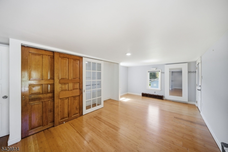 251 Russia Road Oak Ridge, NJ 07438 - Photo 18 of 34 an empty room with wooden floor and cabinet