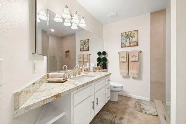 a bathroom with a double vanity sink toilet and a mirror