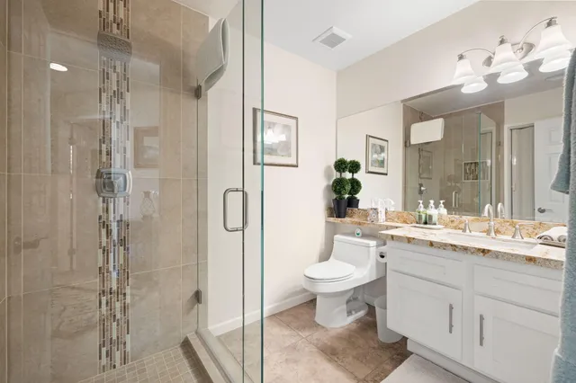 a bathroom with a double vanity sink toilet and shower