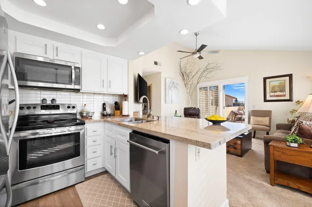 a dining room with furniture a large window and a chandelier