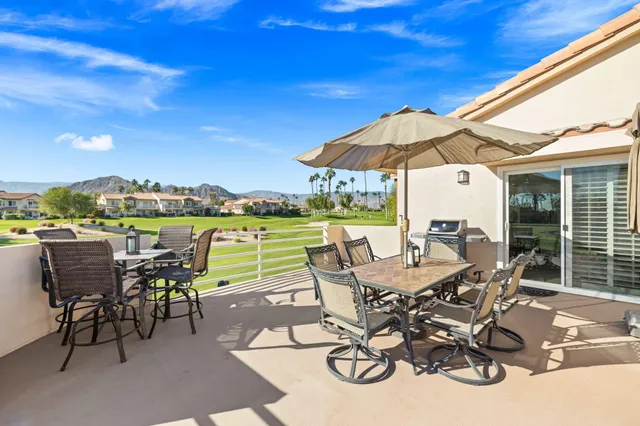 a view of a patio with table and chairs under an umbrella