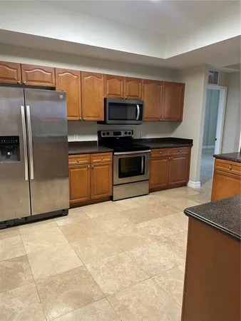 a kitchen with granite countertop a sink window and cabinets