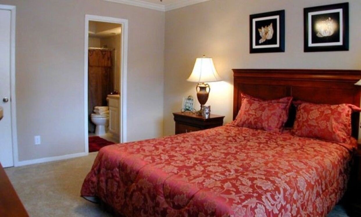 3400 Edloe Street, Unit 302 Houston, TX 77027 - Photo 9 of 13 a large bed sitting in a bedroom next to a lamp