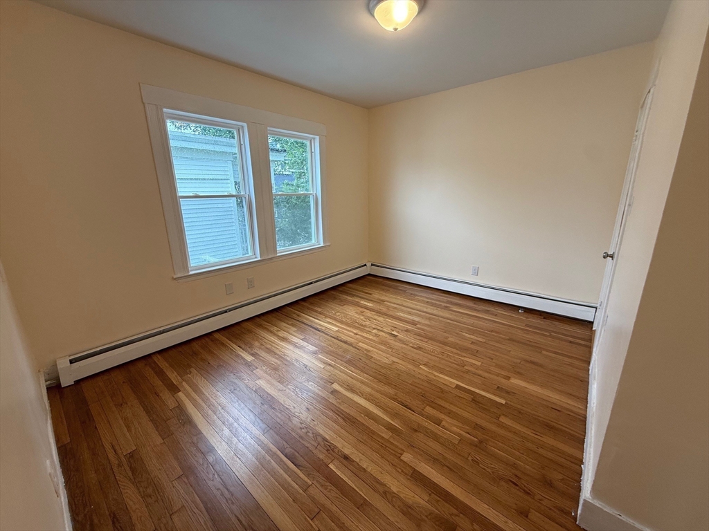 11 Dalrymple Street, Unit 3 Boston, MA 02130 - Photo 7 of 13 an empty room with wooden floor and windows