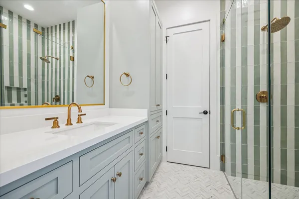 a spacious bathroom with a double vanity sink a mirror and a shower