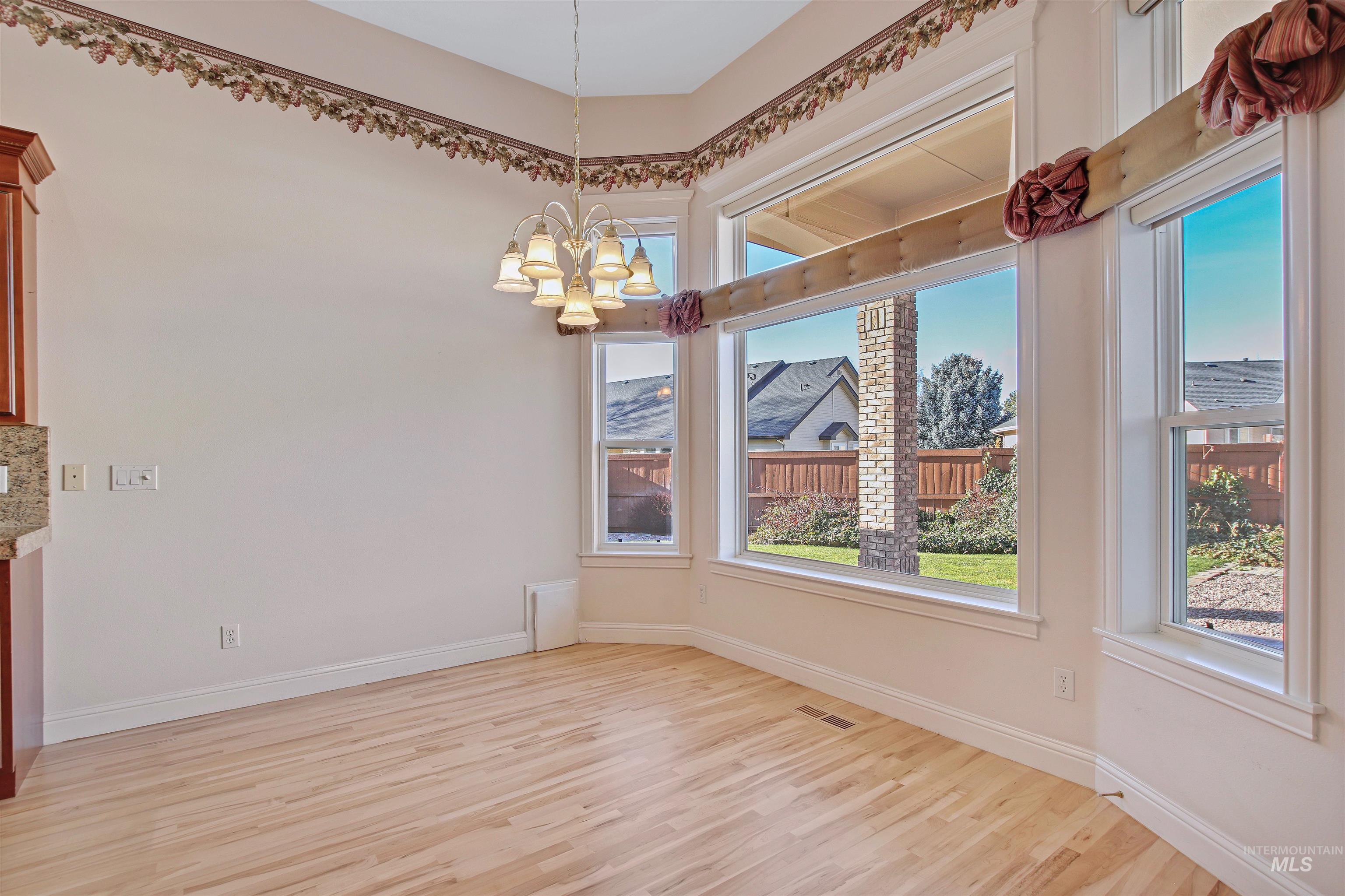 2297 North Chandra Way Meridian, ID 83646 - Photo 19 of 49 Unfurnished dining area featuring light wood finished floors and a chandelier