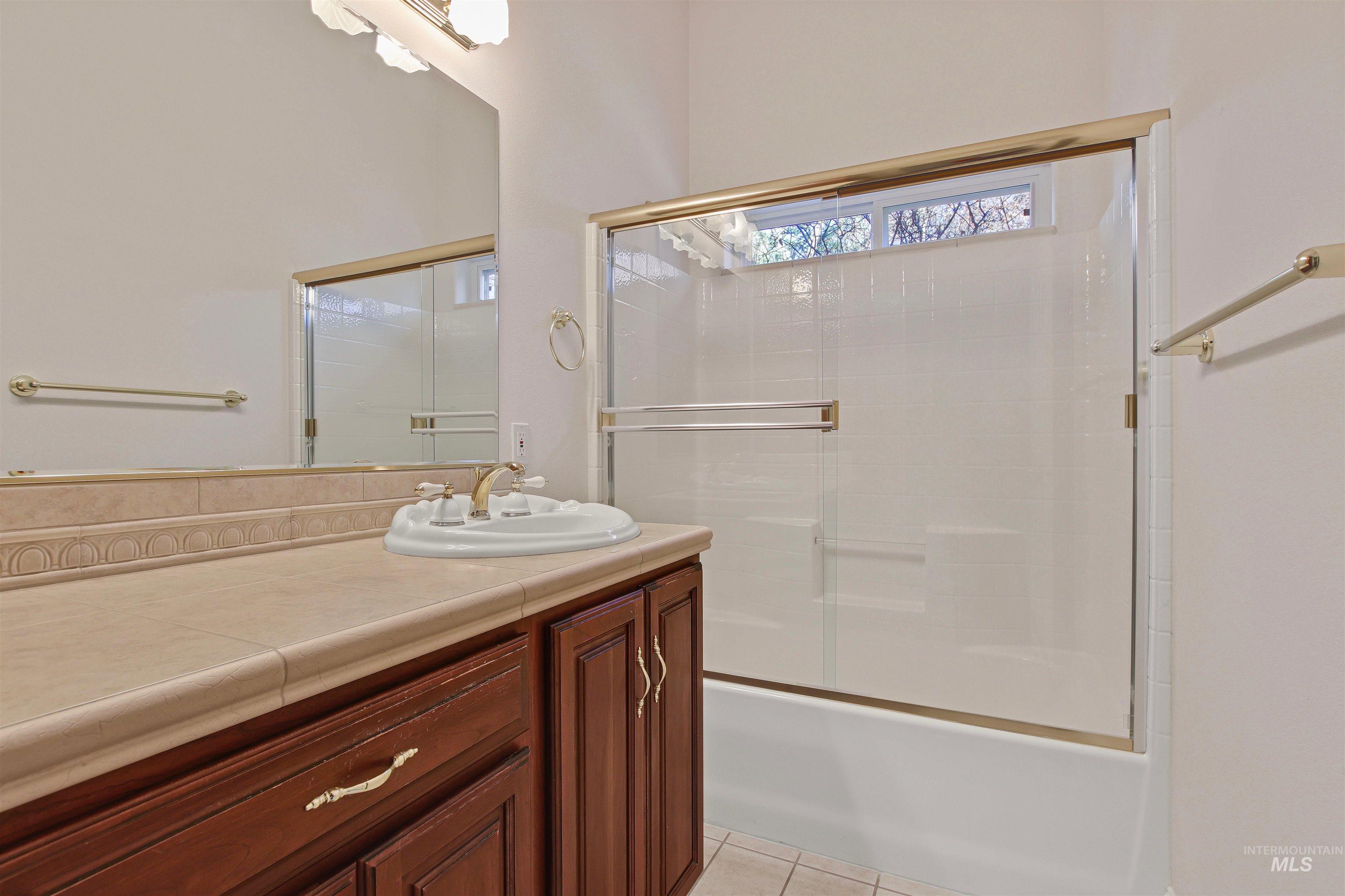 2297 North Chandra Way Meridian, ID 83646 - Photo 42 of 49 Bathroom with vanity, combined bath / shower with glass door, and light tile patterned floors
