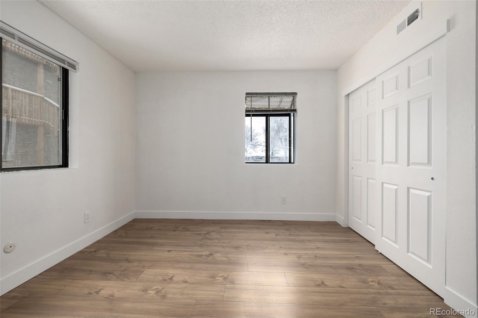 2929 West Floyd Avenue, Unit 201 Denver, CO 80236 - Photo 17 of 28 a view of an empty room with wooden floor and a window