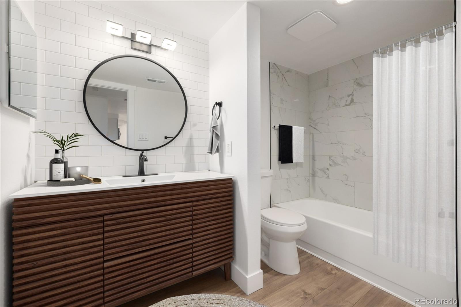2929 West Floyd Avenue, Unit 201 Denver, CO 80236 - Photo 20 of 28 a bathroom with a sink a toilet and a mirror