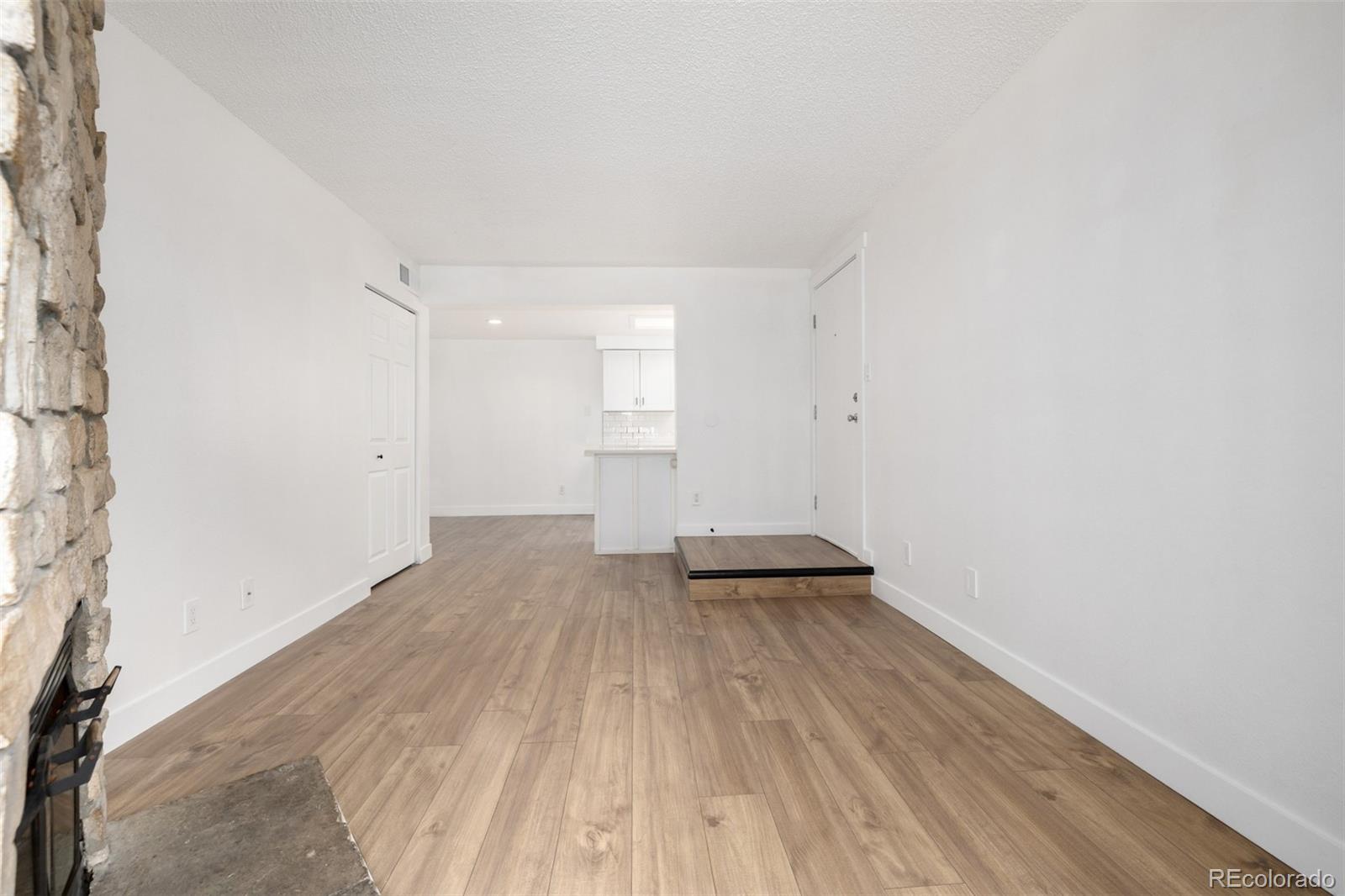 2929 West Floyd Avenue, Unit 201 Denver, CO 80236 - Photo 6 of 28 an empty room with wooden floor