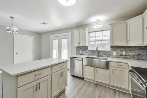 a kitchen with a white cabinets and window