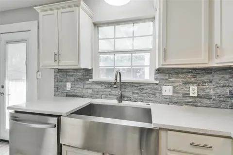 a kitchen with stainless steel appliances granite countertop a sink a stove and cabinets