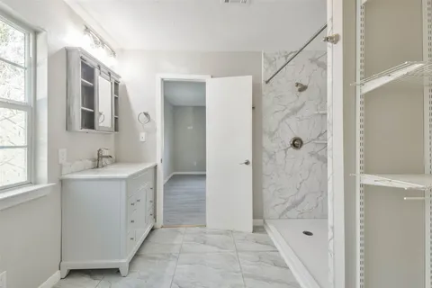 a bathroom with a shower sink and mirror