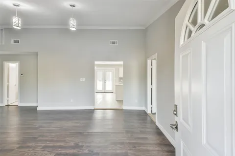 a view of empty room with wooden floor