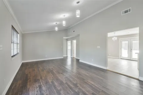 a view of empty room with wooden floor and fan