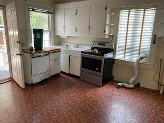 a kitchen with a stove and white cabinets