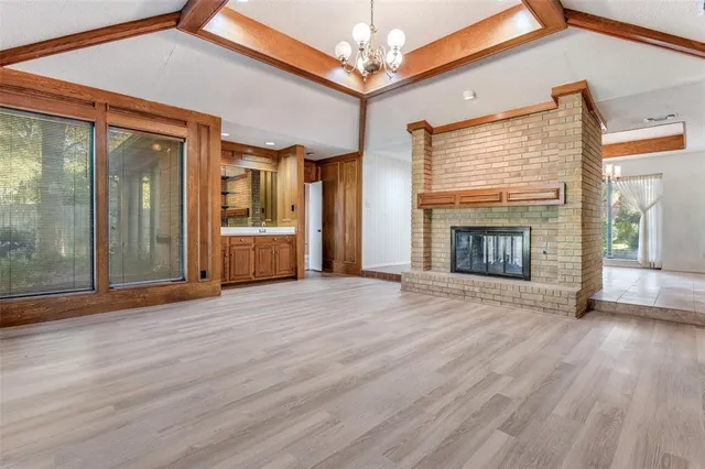 a view of empty room with wooden floor and fireplace