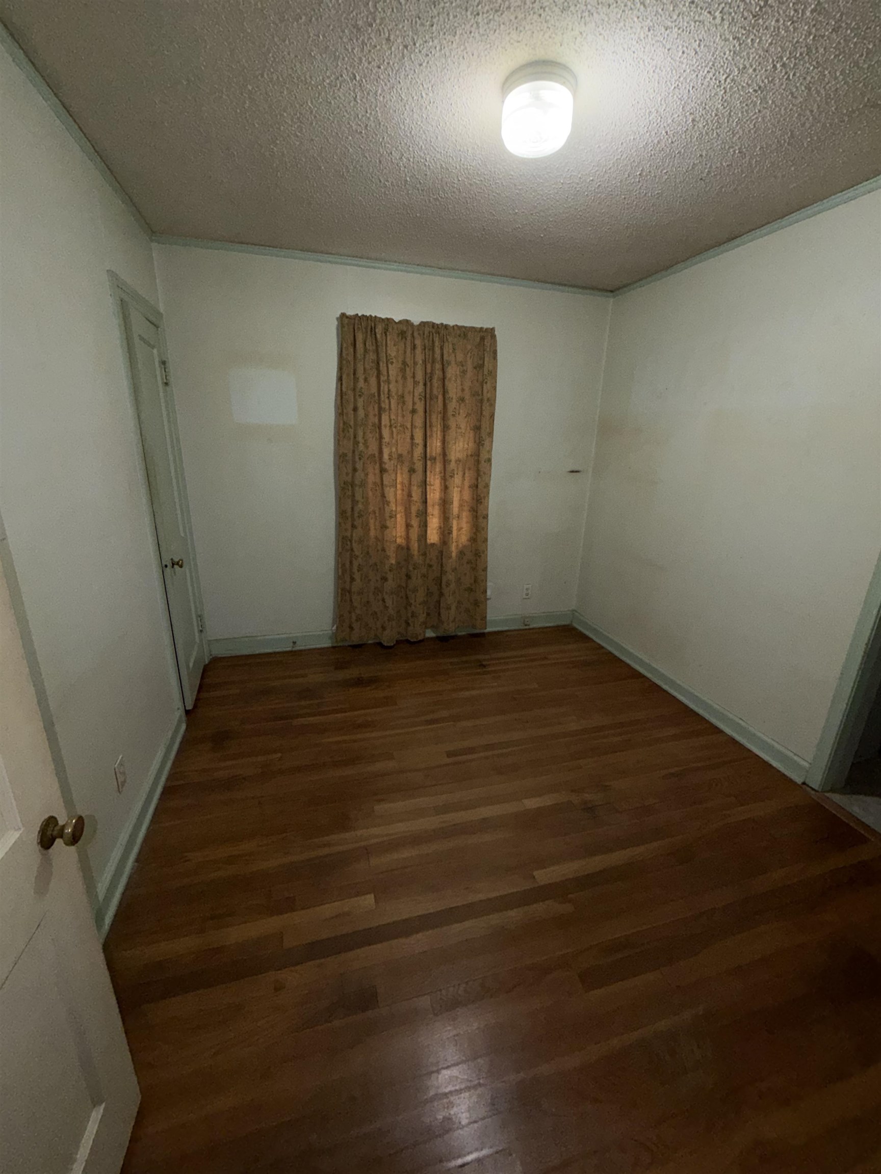 974 Tatum Road Memphis, TN 38122 - Photo 7 of 11 Empty room featuring dark wood finished floors and a textured ceiling