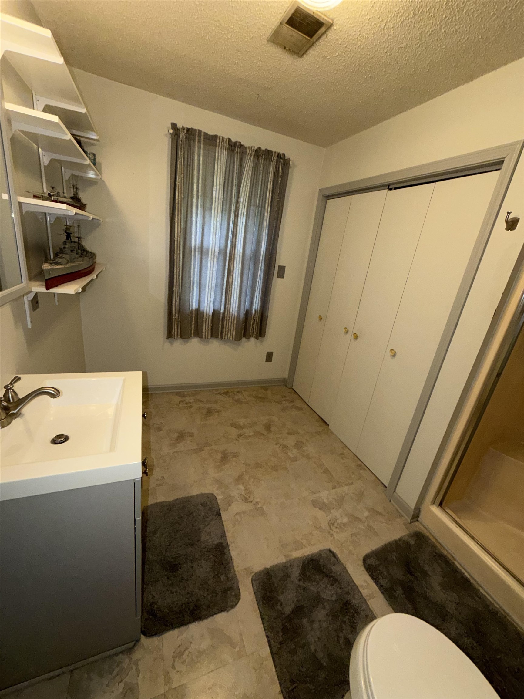 974 Tatum Road Memphis, TN 38122 - Photo 8 of 11 Full bathroom featuring vanity, a shower stall, and a textured ceiling