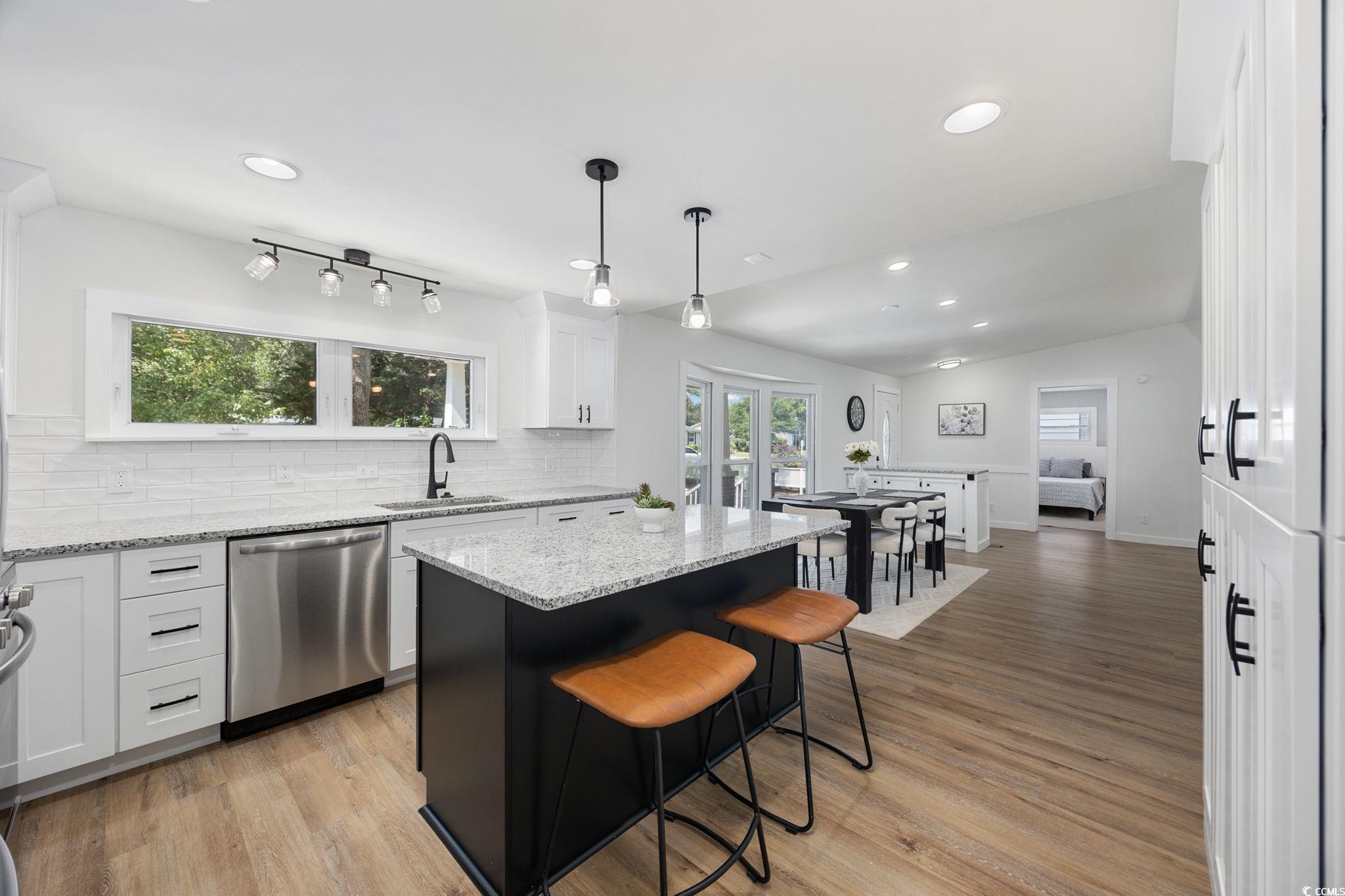 983 South Marlin Circle Murrells Inlet, SC 29576 - Photo 8 of 40 Kitchen with light wood-type flooring, stainless steel dishwasher, recessed lighting, white cabinets, and backsplash
