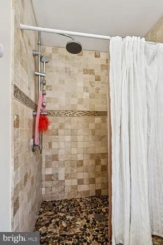 a bedroom with a bed a large window and a chandelier