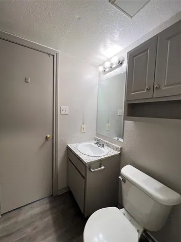 a bathroom with a granite countertop toilet sink and mirror