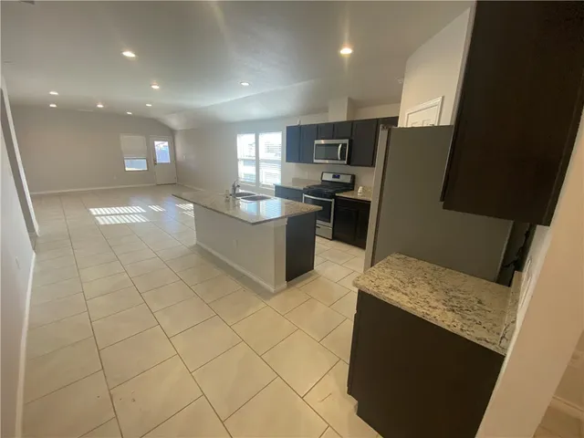 a kitchen with stainless steel appliances a refrigerator sink and microwave