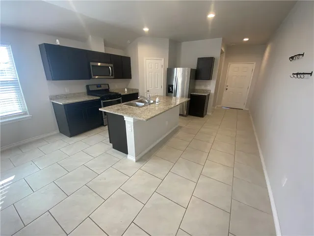 a large white kitchen with a large window and a counter top space
