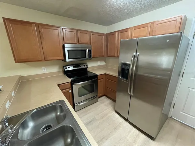 a kitchen with a sink a refrigerator and cabinets