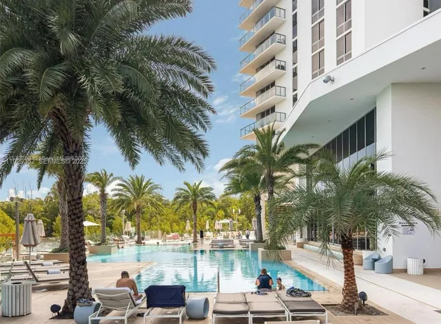 a view of a swimming pool with a lawn chairs and plants