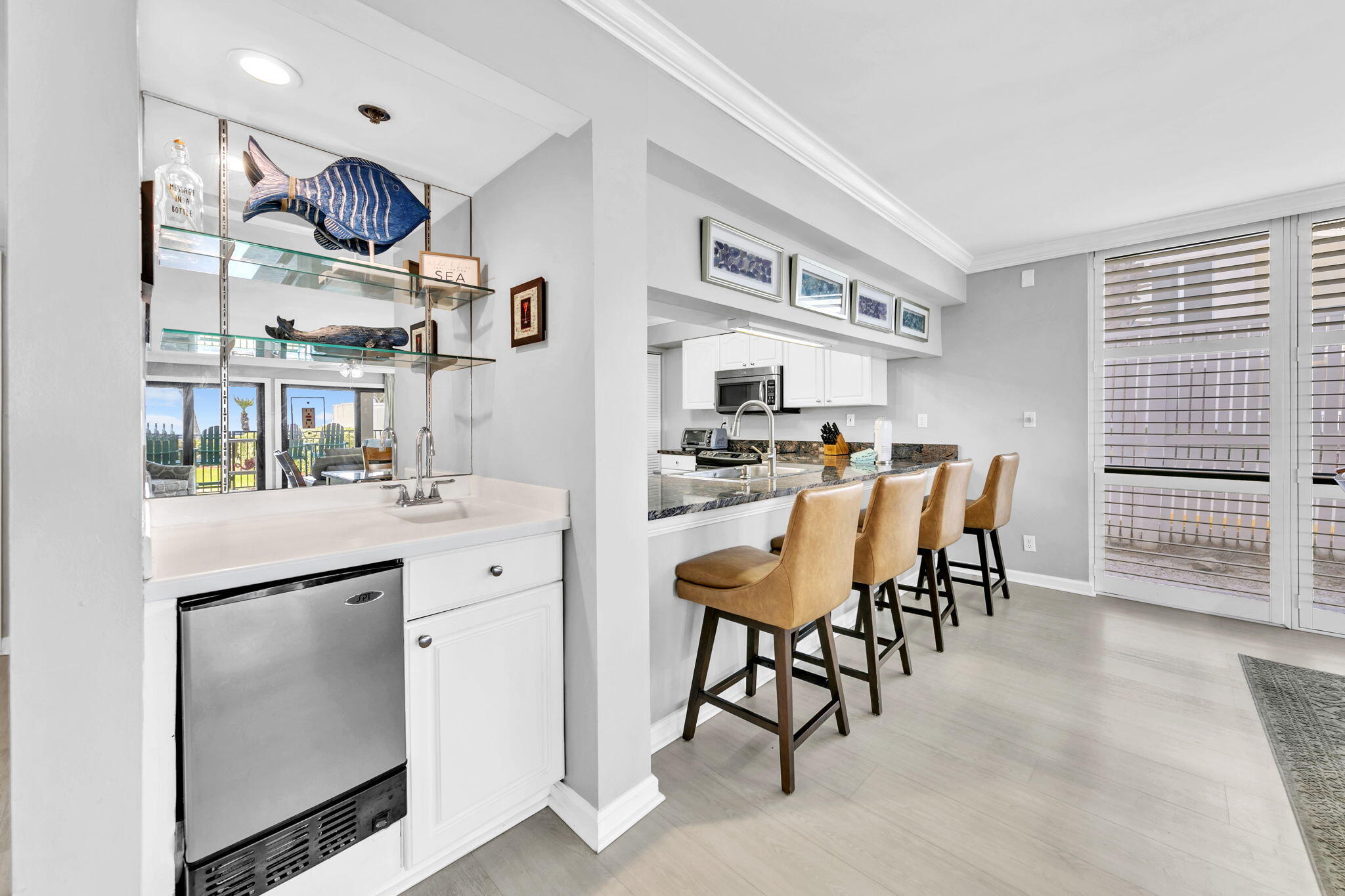 1044 Highway 98, Unit 101 Destin, FL 32541 - Photo 6 of 33 a kitchen with stainless steel appliances kitchen island granite countertop a table and chairs in it