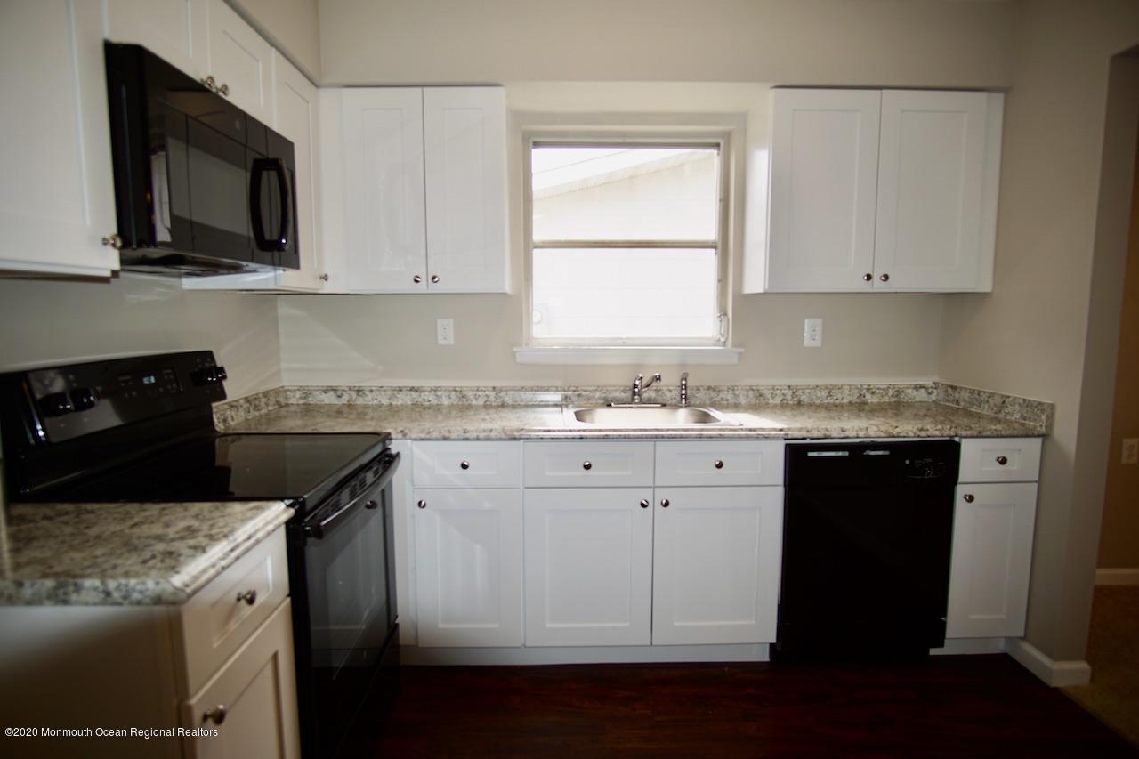 49 Markham Road Brick, NJ 08724 - Photo 5 of 13 a kitchen with granite countertop white cabinets and black appliances