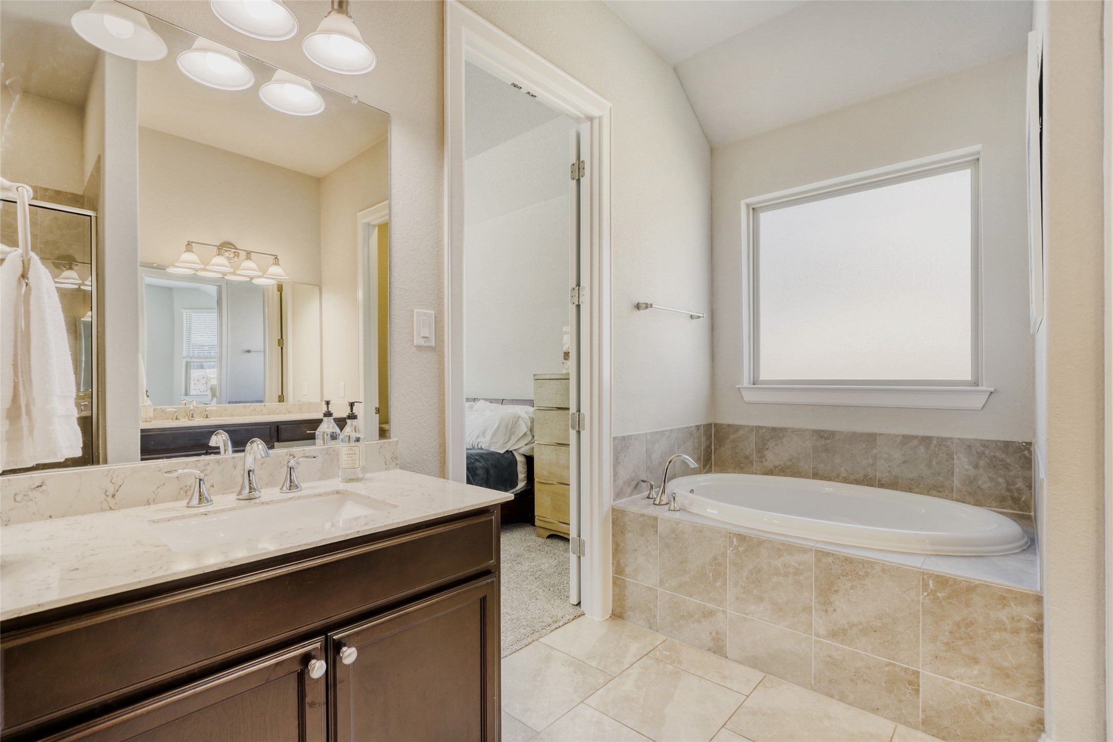 125 Buffalo View Lane Georgetown, TX 78628 - Photo 13 of 28 a bathroom with a granite countertop sink a bathtub a mirror and a shower