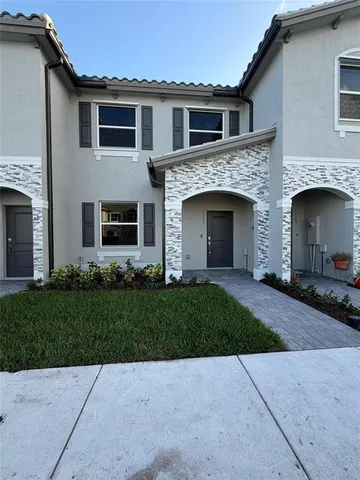 a front view of a house with a garden and yard