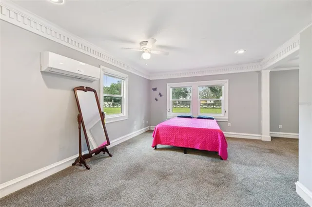 a view of a hallway with wooden floor and a bathroom