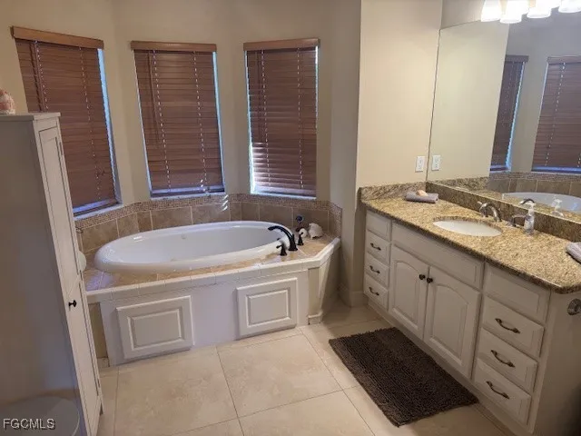a bathroom with a tub sink and mirror