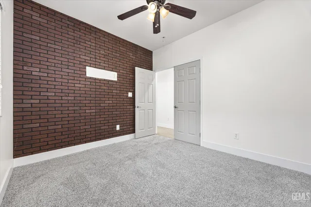 an empty room with a window and a ceiling fan